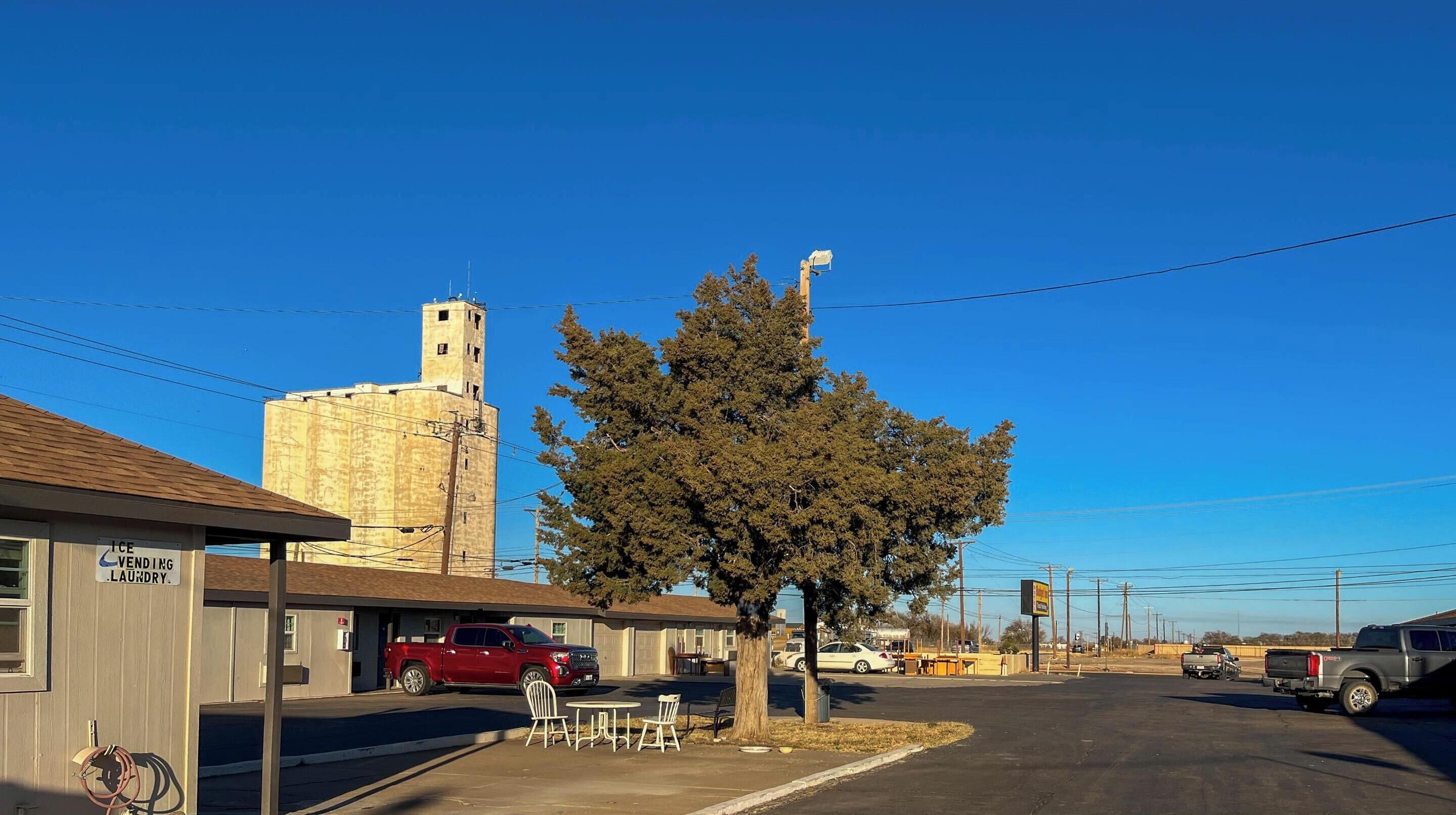 A building with a sign for ice vending and laundry services, a red truck parked in front, and a clear blue sky.