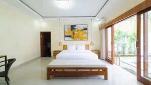 Un dormitorio moderno con una cama grande, mesitas de noche, una silla y un ventanal con vistas a zonas verdes.