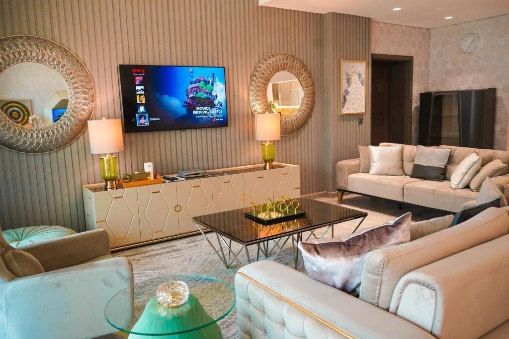 Ein modernes Wohnzimmer mit einer Couch, einem Couchtisch und einem an der Wand befestigten Fernseher.