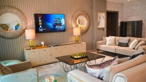 A modern living room with a sofa, a coffee table, and a TV mounted on the wall. - Highend Shoreline Prestige Palm Jumeirah (Dubai)