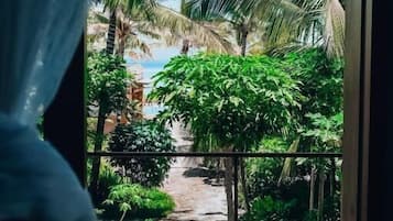 Varanda com vista para uma praia e palmeiras.