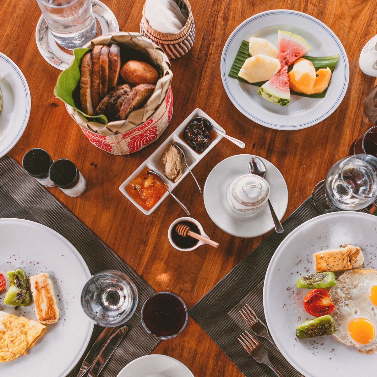 Una mesa de comedor con varios platos, incluyendo un plato de huevos, verduras y un tazón de sopa.