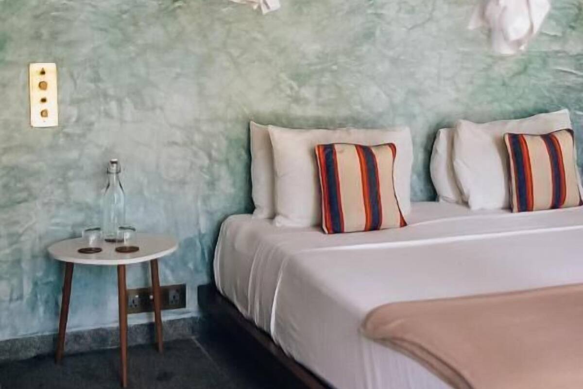 A bedroom with a bed, bedside table, and a nightstand.
