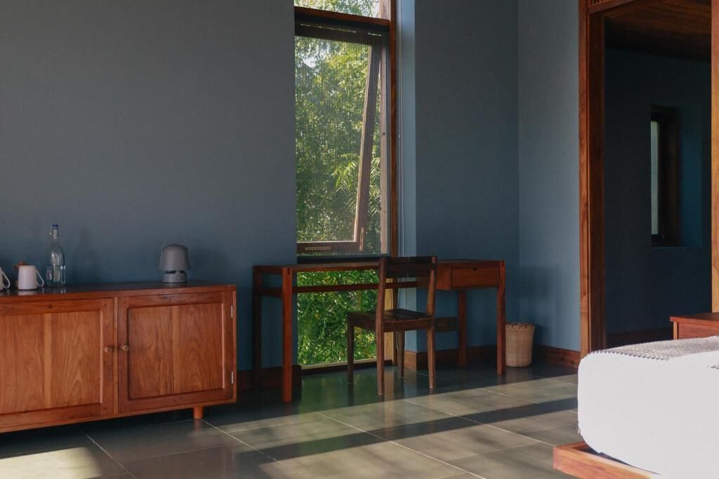 Una habitación con una cama, un armario de madera, una mesa y una silla.