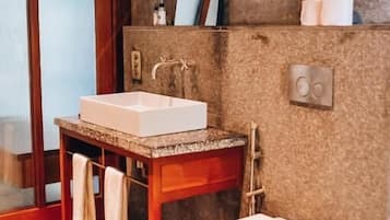 Ein Badezimmer mit einem Holzinlay, einem weißen Waschbecken, einer Toilette und einem Handtuchhalter.