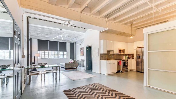 A spacious living area with a kitchen, large windows, and a modern design.