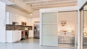 A modern kitchen with white cabinets, stainless steel appliances, and a large island.