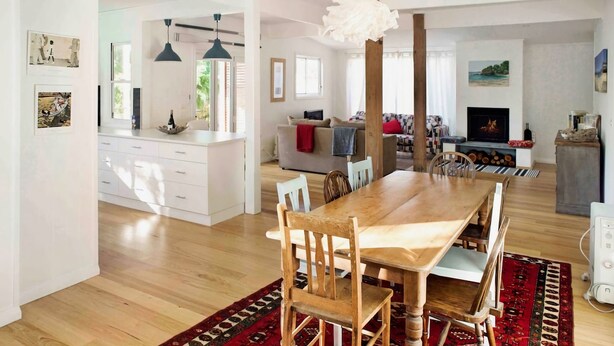 A spacious living area with a wooden dining table, chairs, a sofa, and a fireplace. - Alora Cottage in the heart of Bendalong (Bendalong)