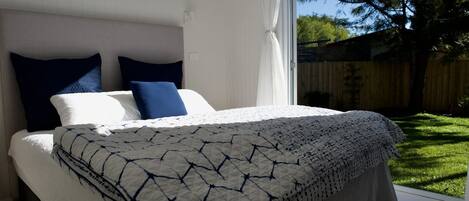 Ein Schlafzimmer mit einem Bett, Kissen und einem Fenster.