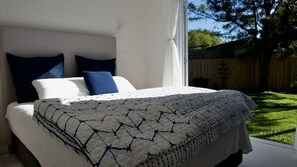 Une chambre à coucher avec un lit, des oreillers et une fenêtre.