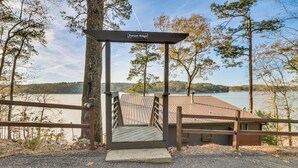 A wooden staircase leading to a gazebo labeled "Sunset Ridge" with a view of a lake and trees. - Private  Lakefront Gem w/ Dock in Talladega (Talladega)