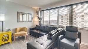 A modern living room with a sectional sofa, a yellow side table, and a black armchair. - 6 Mi to Downtown Cleveland: Lakeview Condo! (Lakewood)