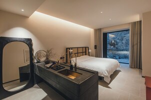 Quarto moderno com uma cama grande, toucador embutido e um espelho amplo.