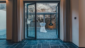 A modern hotel lobby with a glass door leading to a rocky outdoor area. - Ubaia Hotel (Miyun)