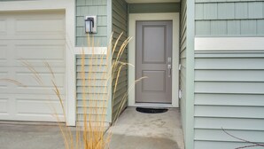 A house with a garage, a front door, and a small porch area.