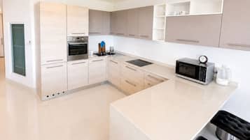 A modern kitchen with a built-in oven, microwave, and coffee maker.