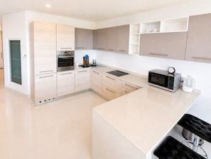 A modern kitchen with a built-in oven, microwave, and coffee maker.