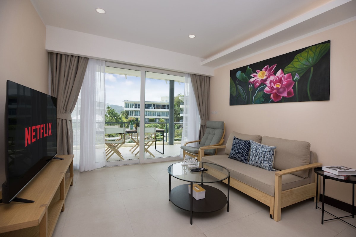 A modern living room with a sofa, coffee table, and a flat-screen TV.
