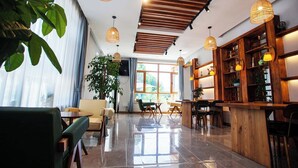 A modern interior with a wooden ceiling, large windows, and a bar area.