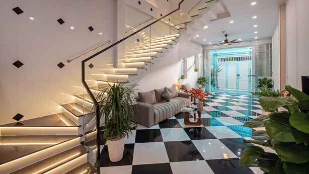 A modern interior with a staircase, a checkered floor, and a sofa. - Mei's house homestay (Da Nang)