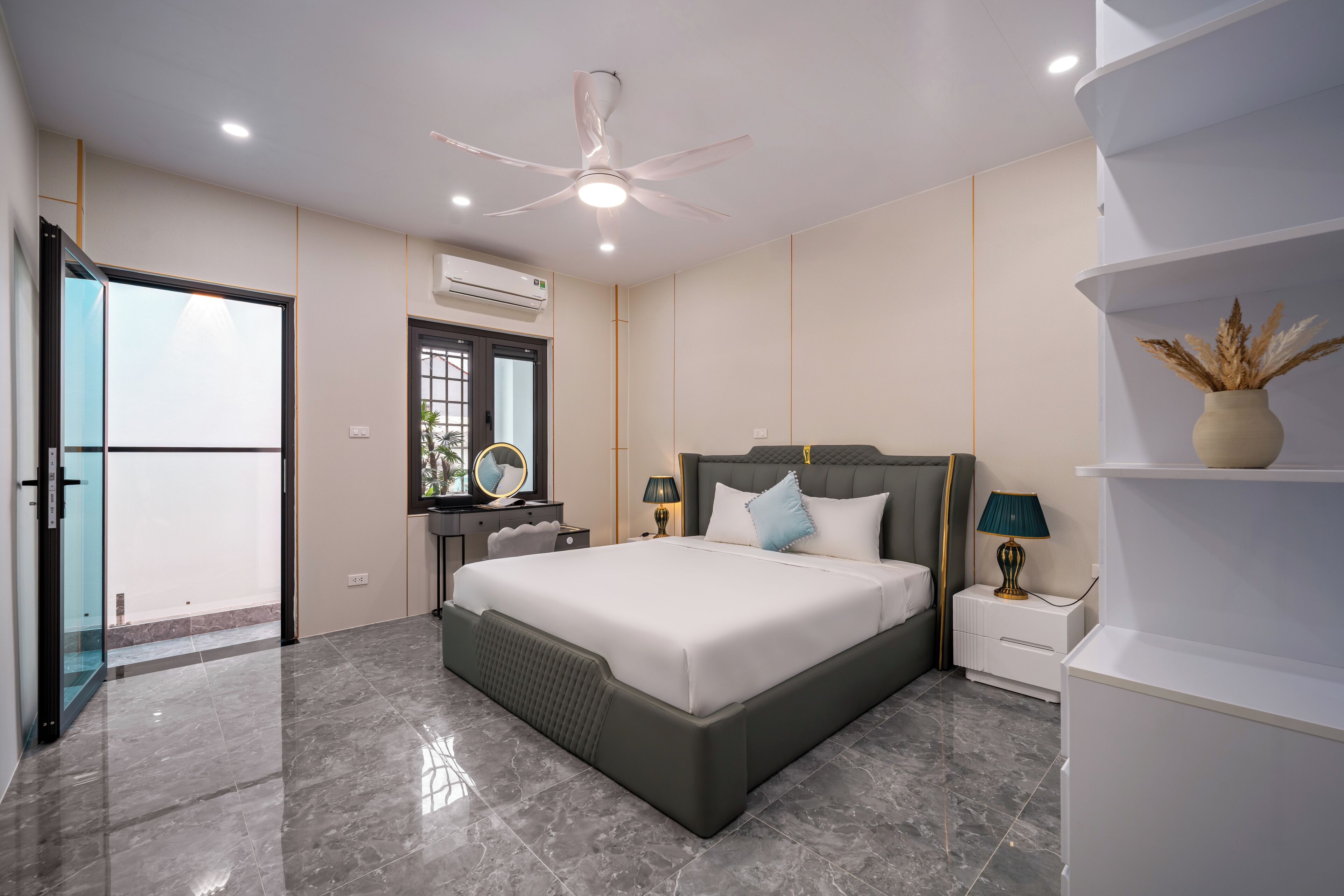 A modern bedroom with a large bed, a ceiling fan, and a nightstand with lamps.