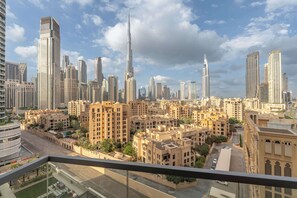 A cityscape with high-rise buildings, including a prominent skyscraper, and residential areas with traditional architecture. - Free housekeeping visits during your stay - StayShort - Stylish Downtown Apartment with Burj Views that Sleeps 4! (Downtown)