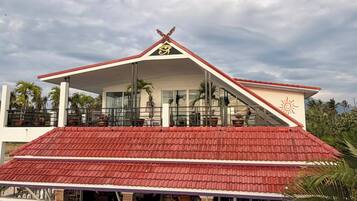 A building with a red roof and a white facade, featuring a prominent symbol on the roof.