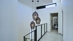 A modern interior with a staircase, glass railing, and pendant lighting. - Mosselbay Waterfront Accomodation  (Mossel Bay)