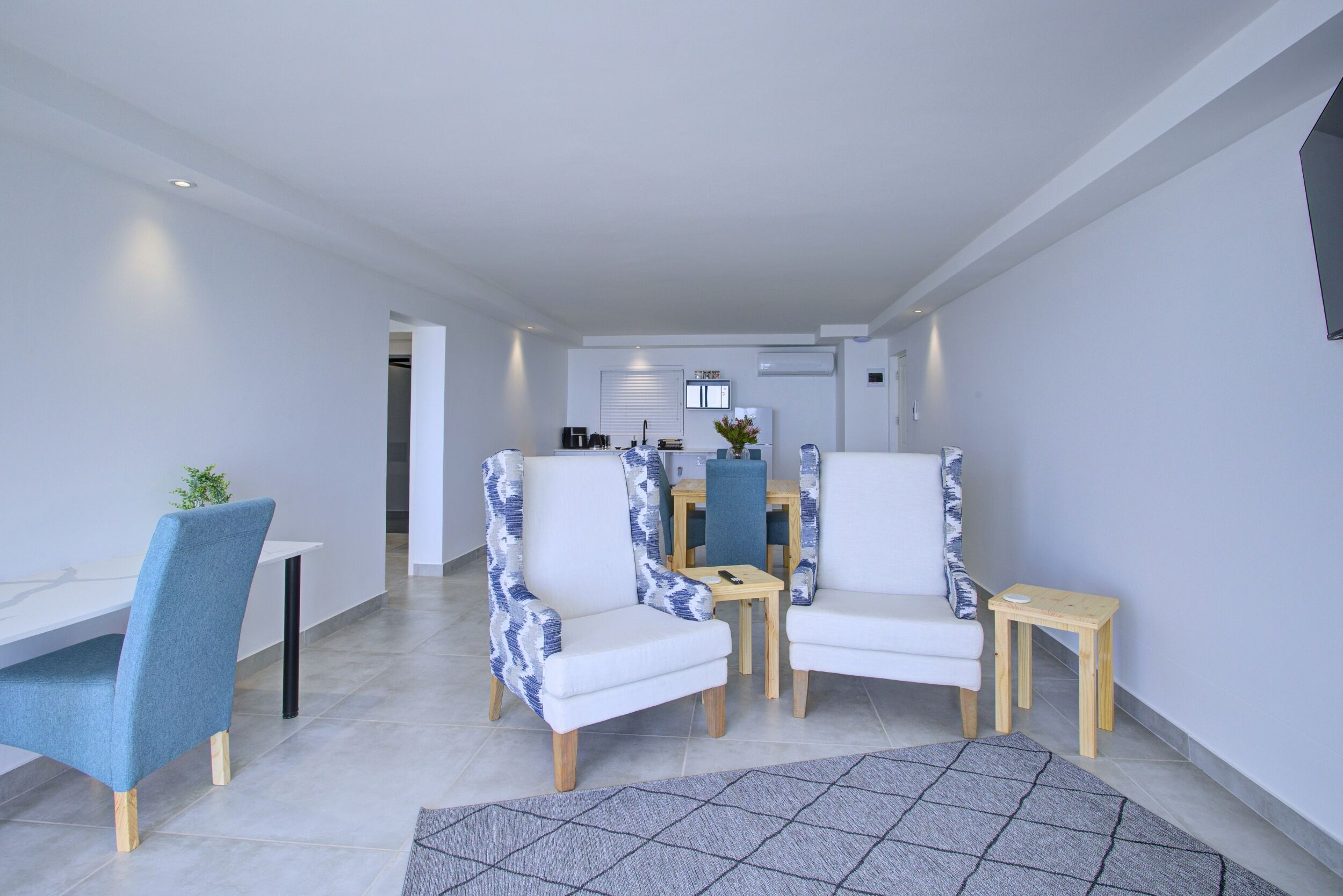 A modern living room with a dining area, featuring a sofa set, a small table, and a coffee table.
