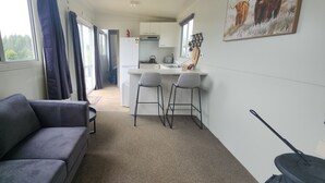 A compact living space with a sofa, a kitchenette, and a dining area.