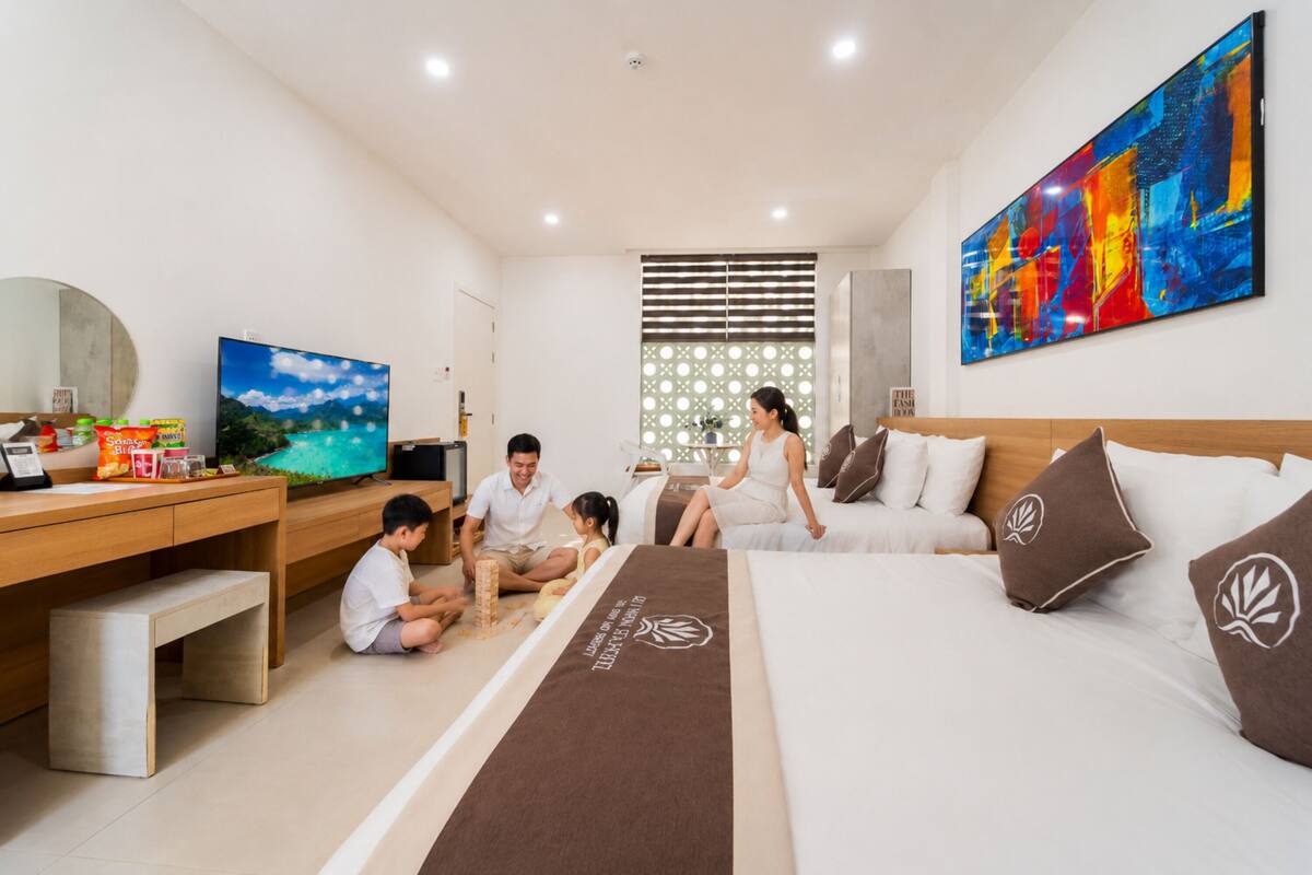 Una habitación de hotel moderna con una cama, un escritorio, un televisor y un cuadro abstracto grande.