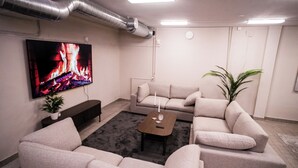 Un salon équipé d’un téléviseur à écran plat, de canapés, d’une table basse et d’une plante en pot.
