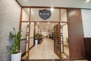 A reception area with a sign reading "KAYAL RESIDENCY," potted plants, and a reception desk. - KAYAL RESIDENCY (Gobichettipalayam)