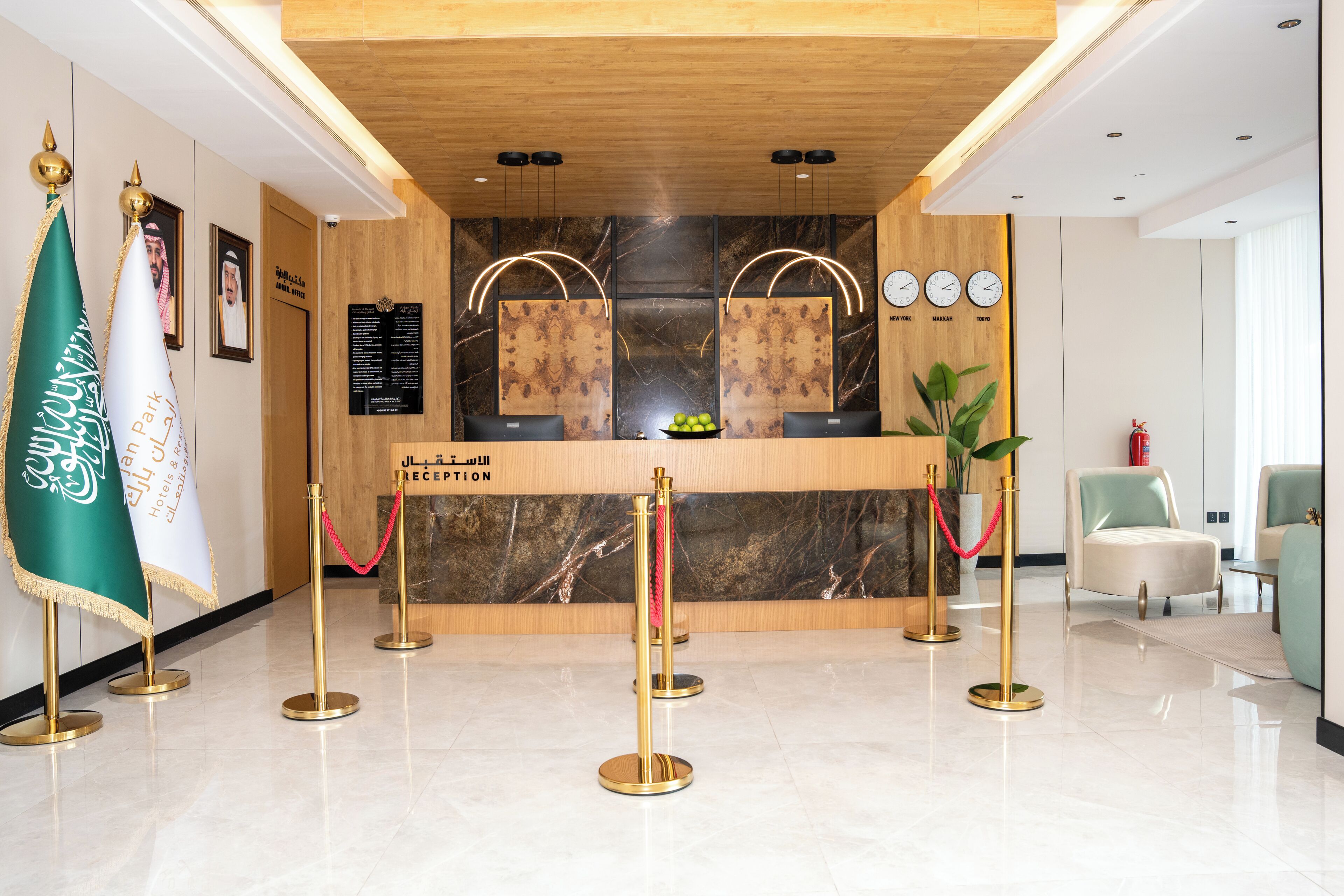 Een hotel receptie met een marmeren balie, gouden linten en een vlag.