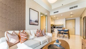 Un salon moderne comprenant un canapé, une table basse et un coin repas avec des chaises et une table.
