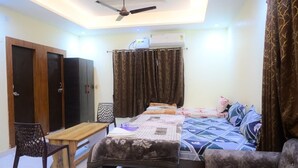 Un dormitorio con cama, escritorio, silla, armario y ventilador de techo.