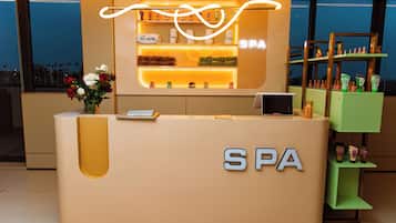 Un comptoir d’accueil avec une enseigne indiquant « SPA » et un présentoir de produits de toilette.