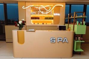 A reception desk with a sign reading 'SPA' and a display of toiletries. - Bio Hôtel (Lomé)