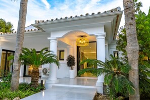 A modern building with a white facade, columns, and a large entrance with a chandelier. - Villa 'Beach-side 5B' with Private Pool, Private Terrace and Air Conditioning (El Paraíso)