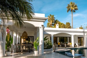 A modern house with a pool, white columns, and tropical plants. - Villa 'Beach-side 5B' with Private Pool, Private Terrace and Air Conditioning (El Paraíso)