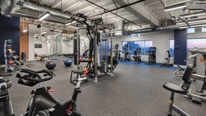 A gym with various exercise equipment, including treadmills, weight machines, and free weights. - Studio Apartment with Amazing Downtown Los Angeles Views (Los Angeles)