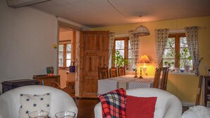 A cozy living room with a dining table, chairs, a lamp, and a window with curtains. - 3 bedroom cozy home in Trelleborg (Trelleborg)