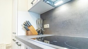 Una cocina moderna con estufa de acero inoxidable, un bloque de cuchillos de madera y salpicadero.