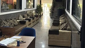A spacious lobby with a reception desk, seating areas, and a staircase leading to an upper floor. - Hotel Divines Residency  (Noida)