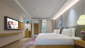 A modern hotel room with a large bed, bedside tables, a flat-screen TV, and a bathroom visible through a glass door. - The Hotel V  Huai'an  University Town (Huai'an)