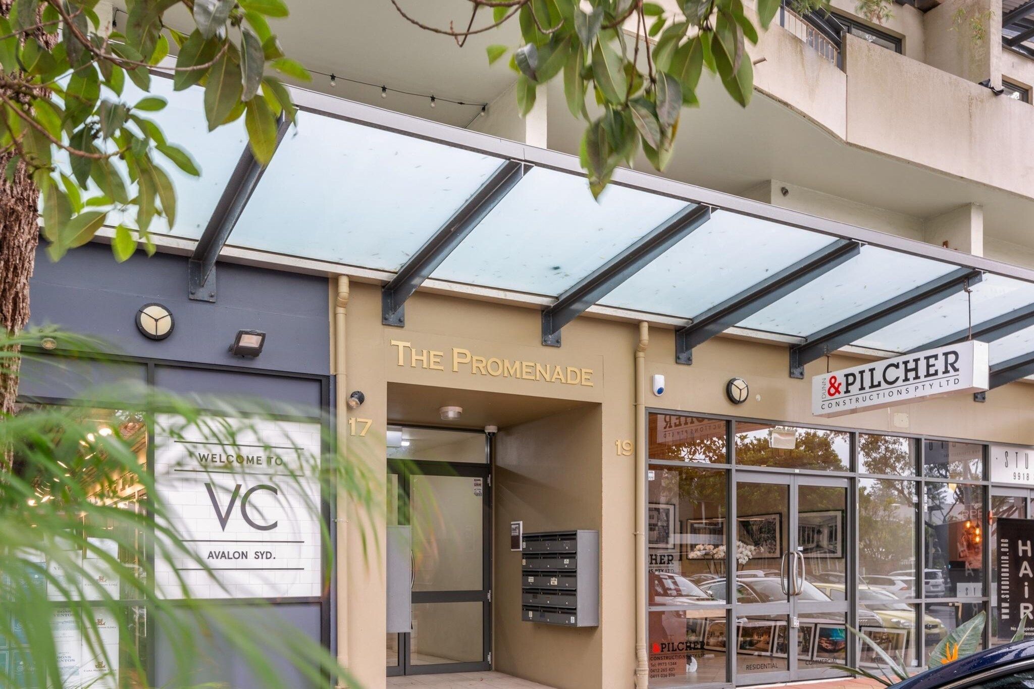 A commercial building with a storefront for 'The Promenade' and 'Pilcher Constructions Pty Ltd'.