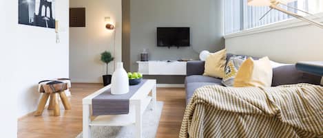A modern living room with a sofa, coffee table, and a flat-screen TV.