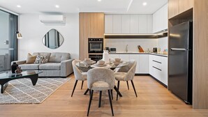 Une cuisine moderne avec un coin repas, comprenant une table ronde, des chaises et un canapé.