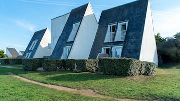 Un edificio moderno con varios techos inclinados y paredes exteriores en blanco y gris oscuro.