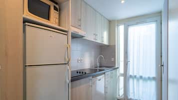 Una cocina moderna con microondas, refrigerador y lavamanos.